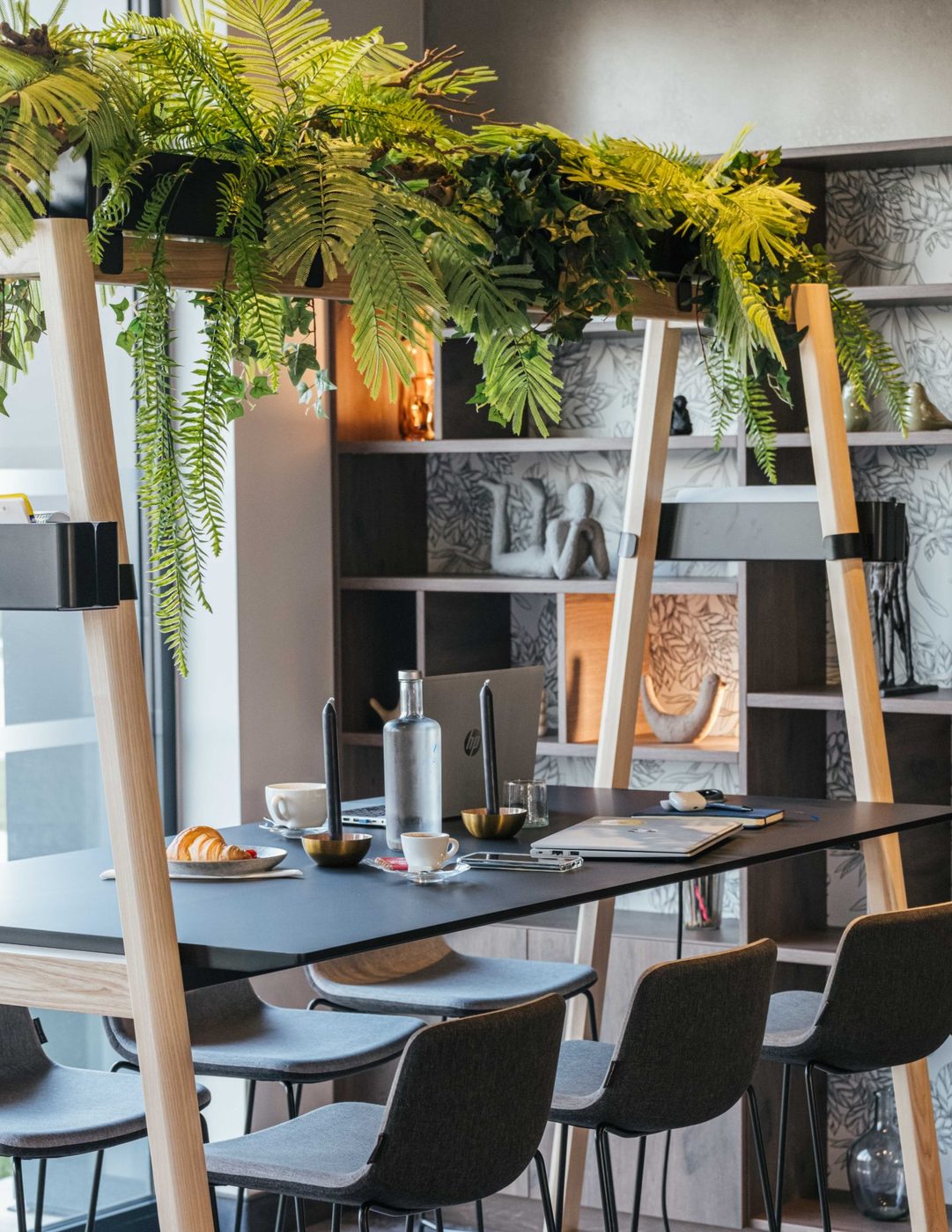 Espace de travail du Kyriad Châteauroux Nord Aéroport avec grande table haute et végétation suspendue